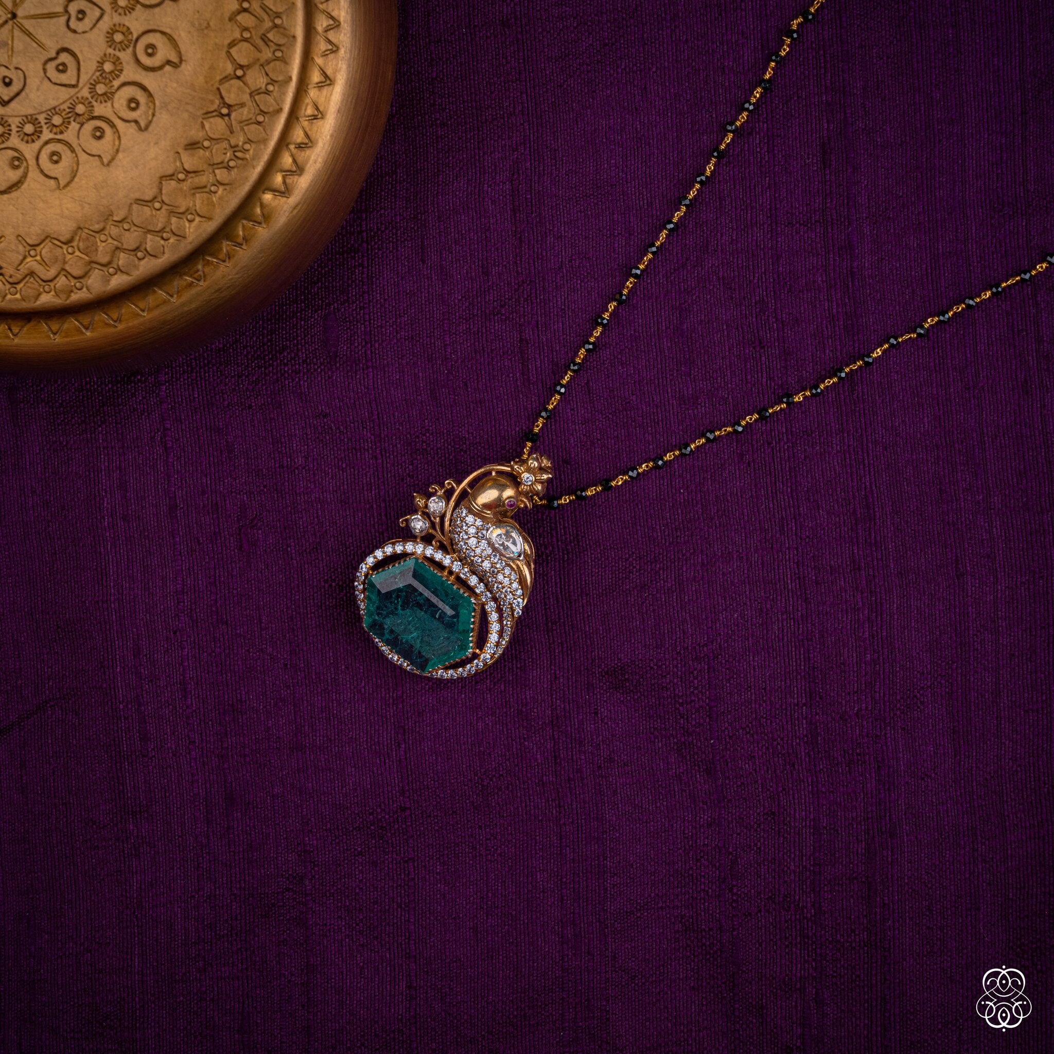 Kekavali emerald peacock pendant styled on a black bead chain