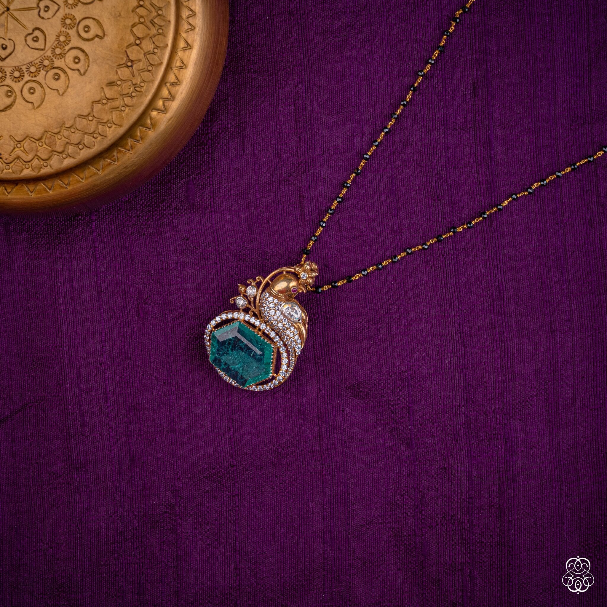 Kekavali emerald peacock pendant styled on a black bead chain
