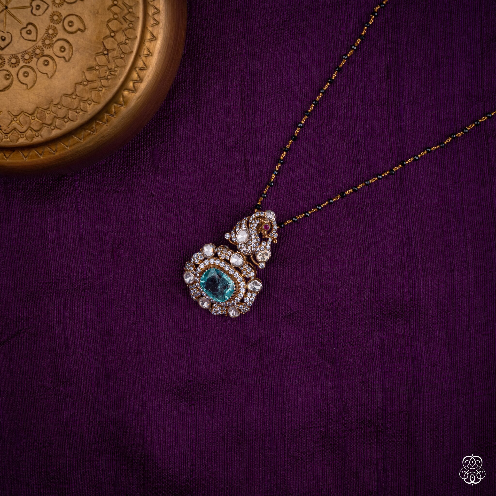 Shikhandini aqua emerald peacock pendant styled on a black bead chain
