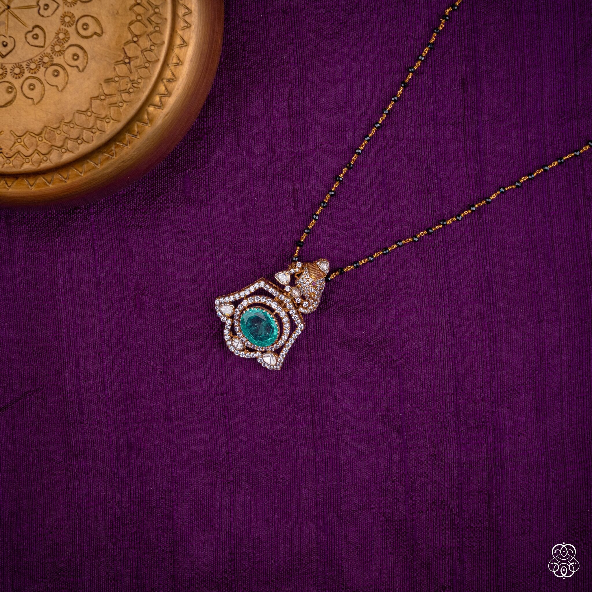 Suvarna Shuka parrot emerald pendant styled on a black bead chain