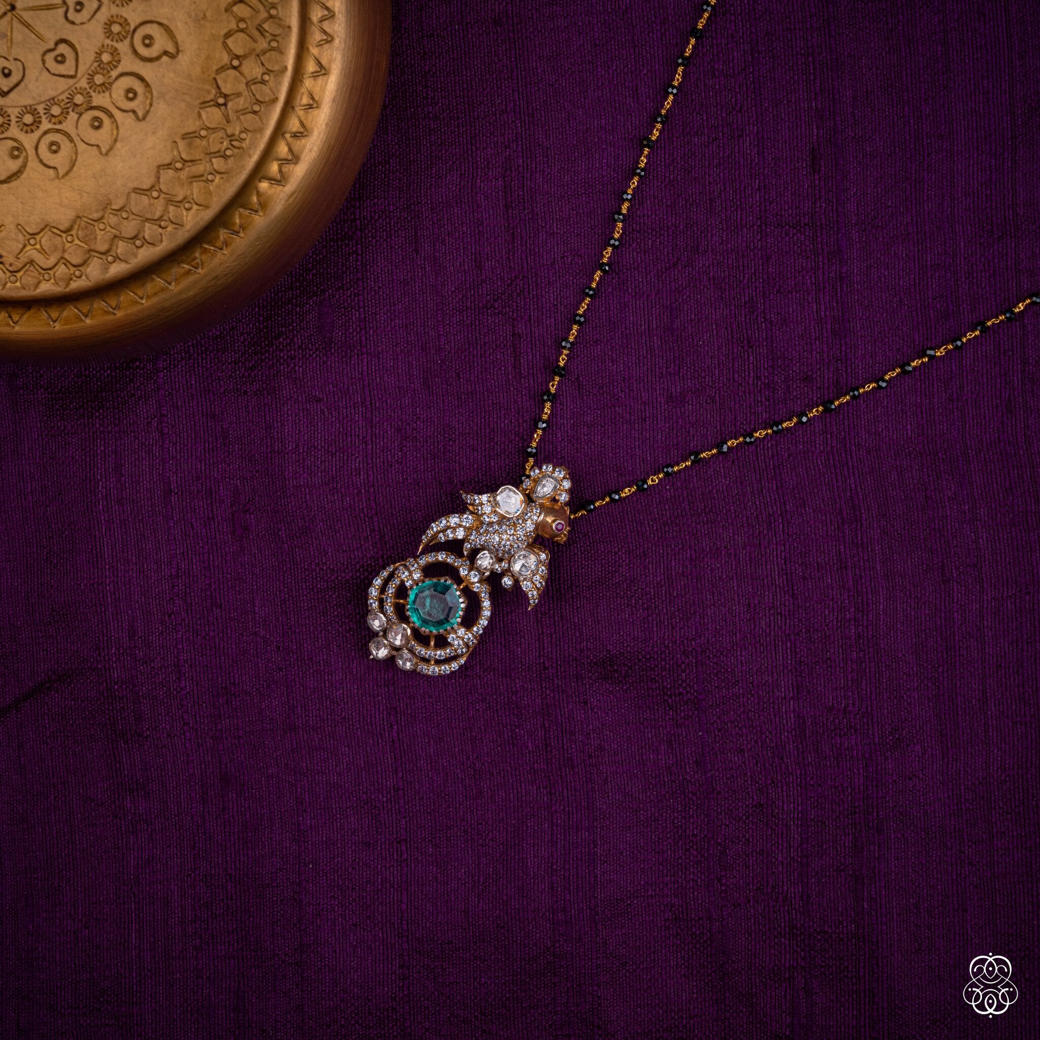 Chakravaki emerald bird pendant styled on a black bead chain