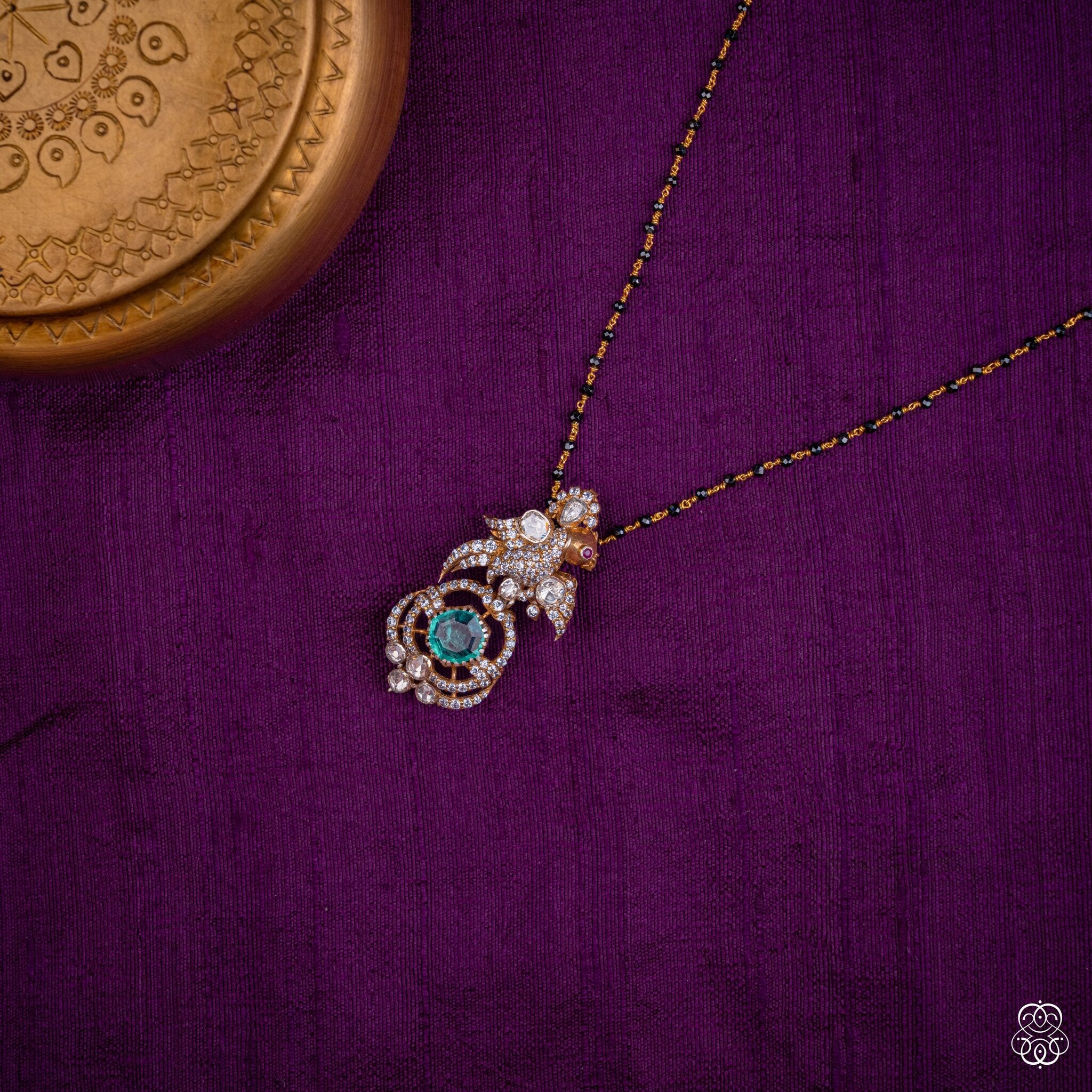 Chakravaki emerald bird pendant styled on a black bead chain