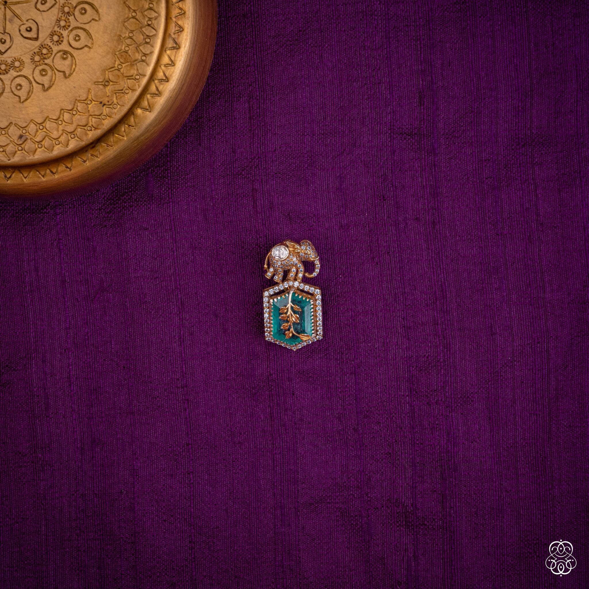 Gajaharita elephant pendant with a green lab-grown emerald hexagon and gold leaf detailing in 92.5 sterling silver with 22k gold plating
