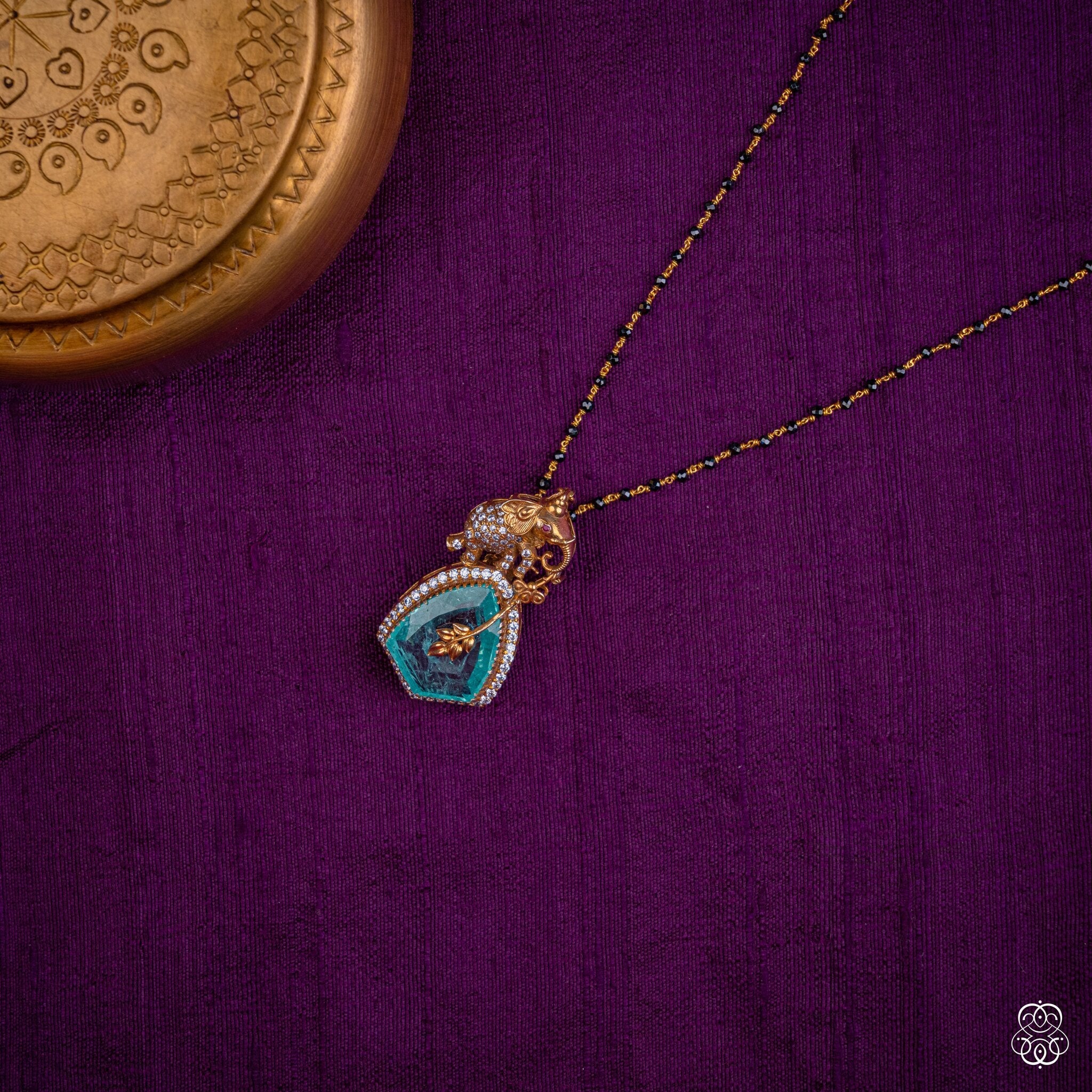 Gajapallava elephant emerald slice pendant styled on a black bead chain