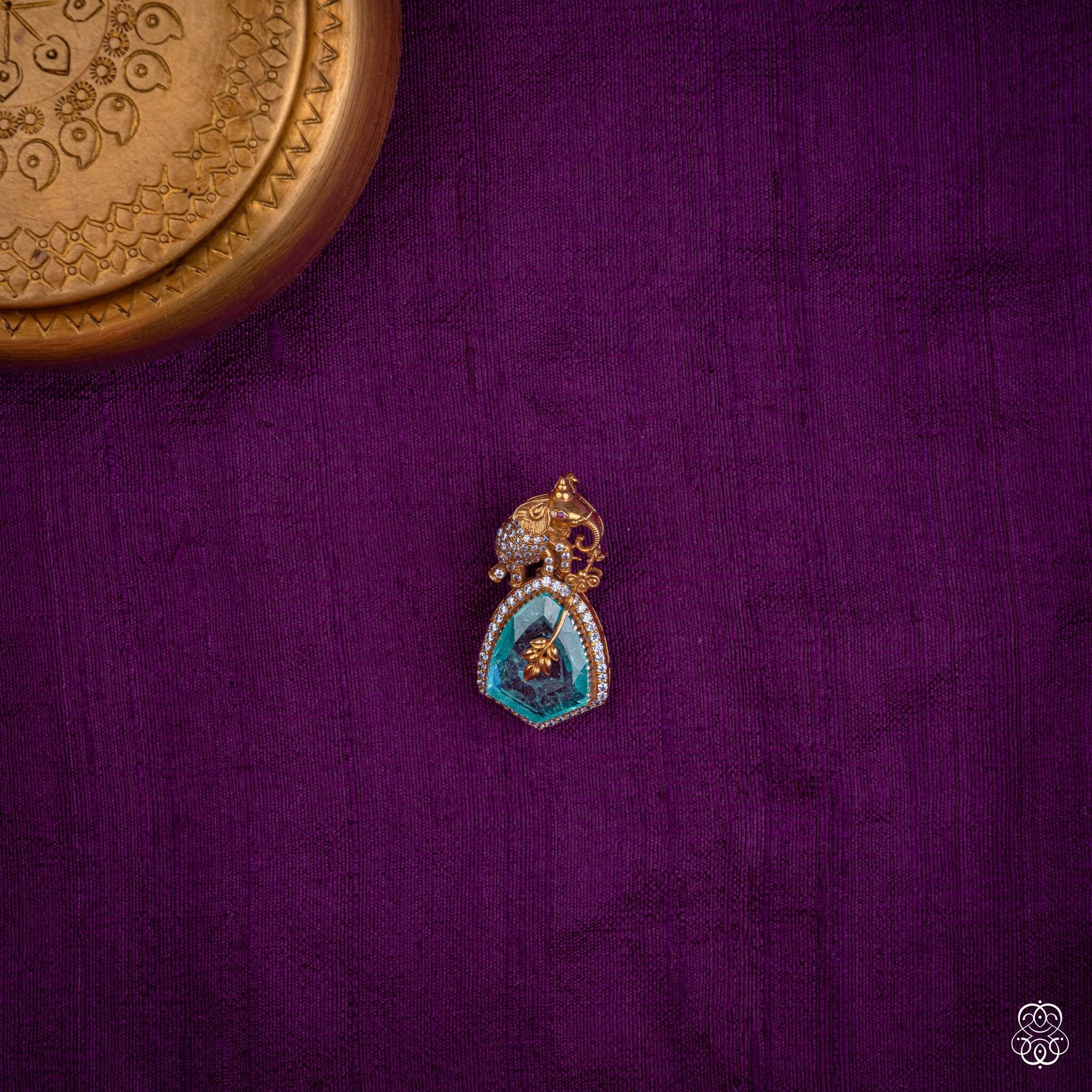 Gajapallava elephant pendant with a lab-grown emerald slice and gold leaf detailing in 92.5 sterling silver with 22k gold plating