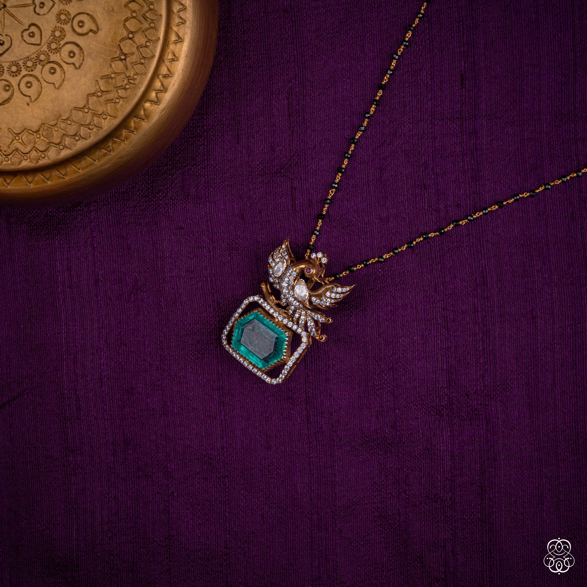 Hamsayugma swan emerald pendant styled on a black bead chain