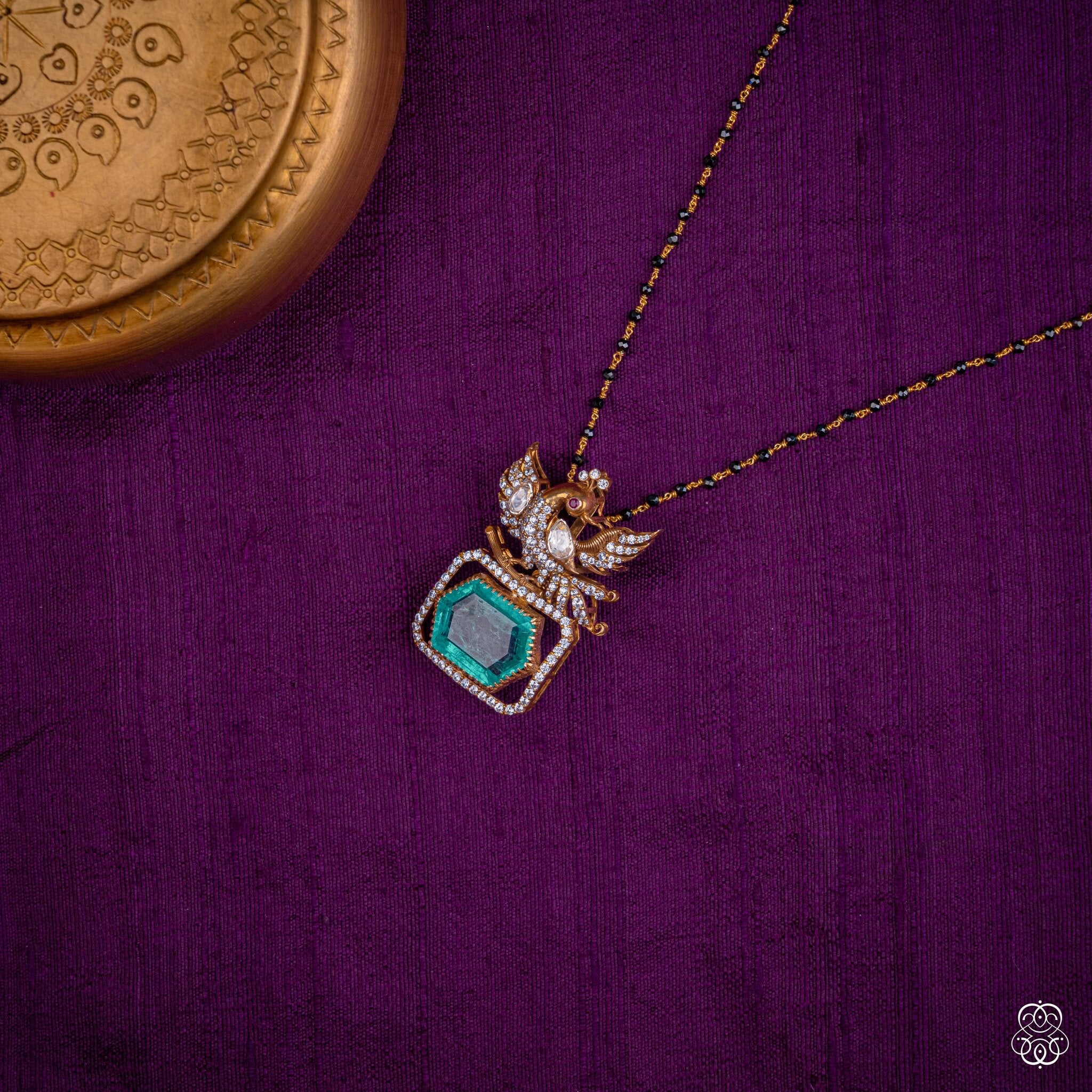 Hamsayugma swan emerald pendant styled on a black bead chain