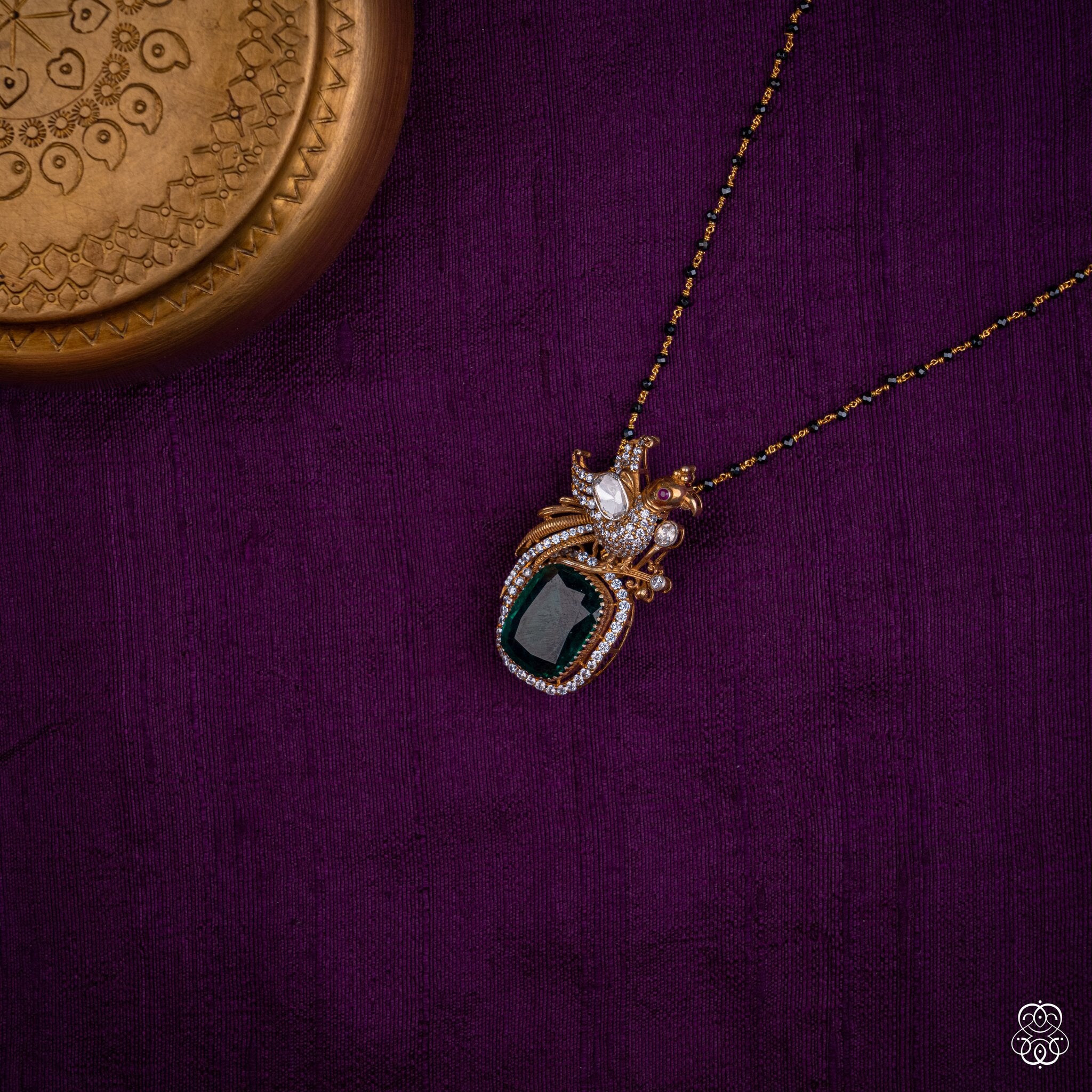 Kalapini emerald peacock pendant styled on a black bead chain