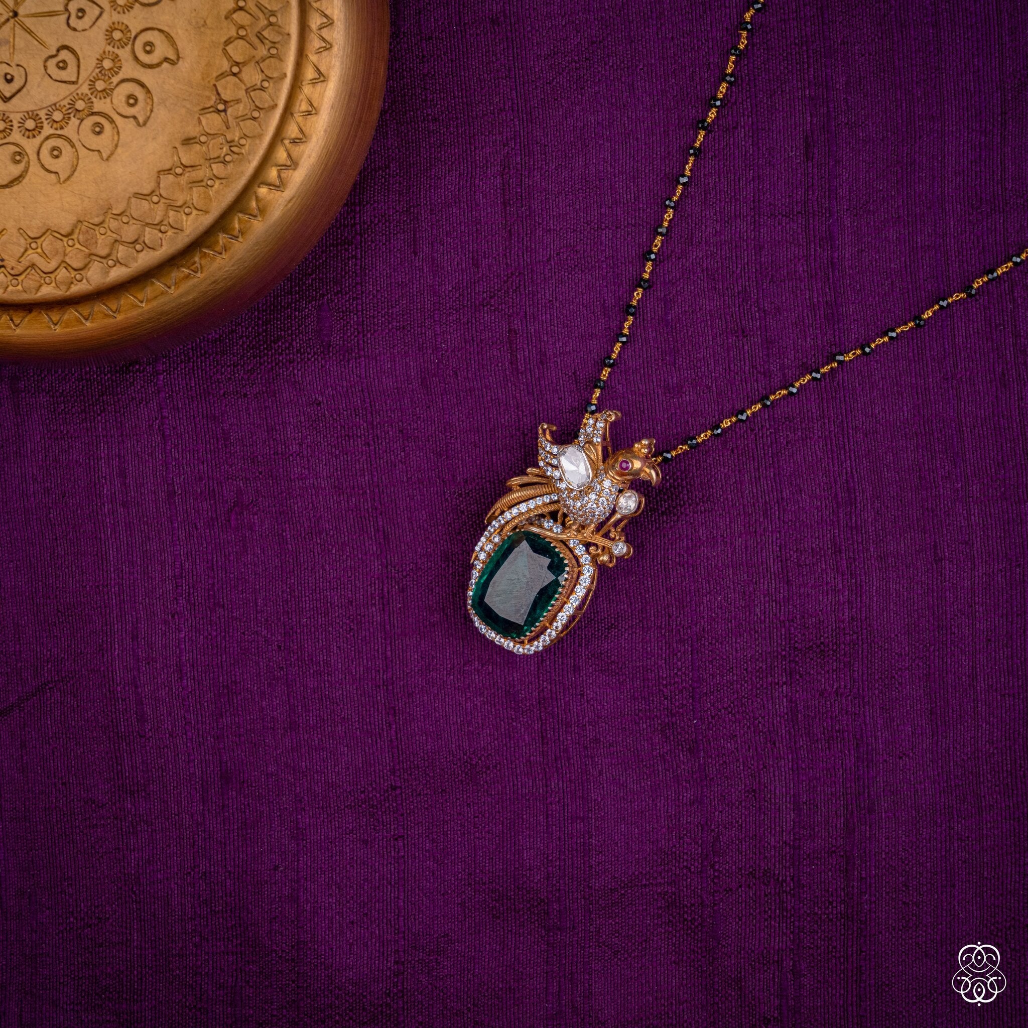 Kalapini emerald peacock pendant styled on a black bead chain