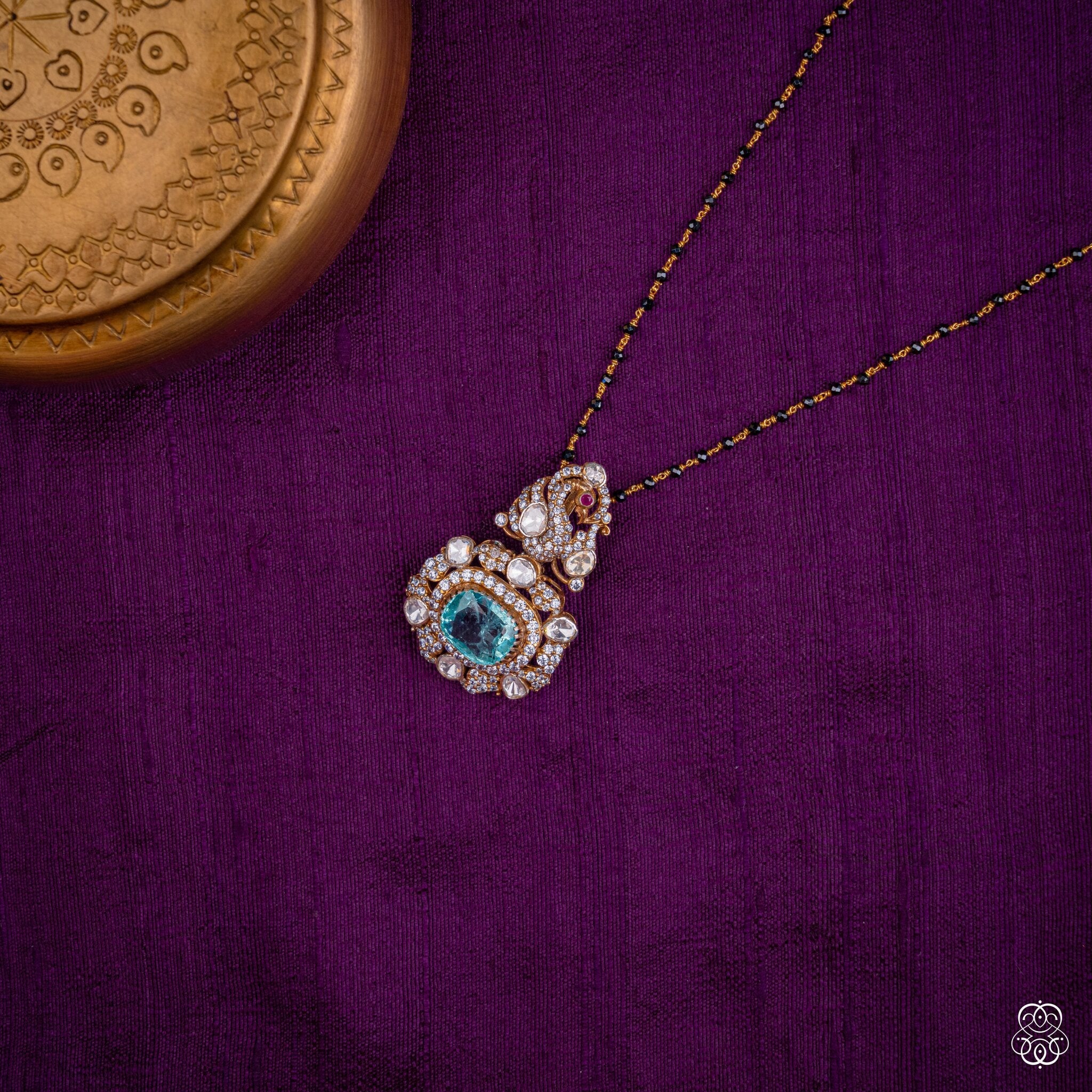 Shikhandini aqua emerald peacock pendant styled on a black bead chain