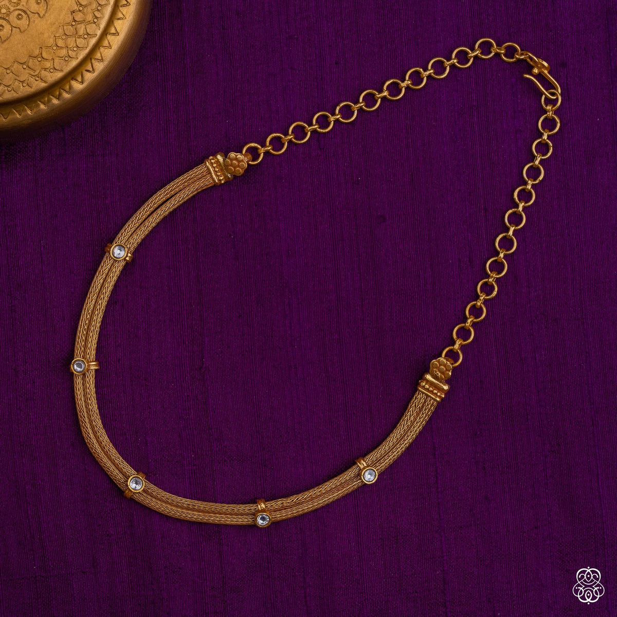 Close view of the moissanite settings on the Venimala braided gold necklace